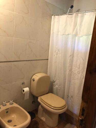 a white bathroom with a toilet and a sink at Claro de Luna 2 in Villa Gesell
