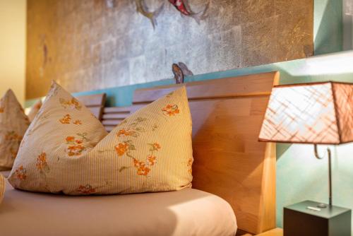 a bedroom with a bed with two pillows and two lamps at SCHUSTERjunge Aparthotel in Sasbachwalden