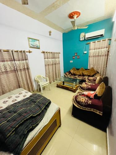 a bedroom with two beds and a blue wall at Prayagraj Sangam Homestays in Naini