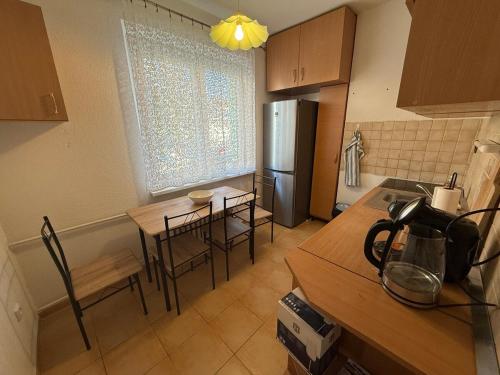 a kitchen with a table and chairs and a refrigerator at GOOD VIBES ONLY apartman in Zvolen