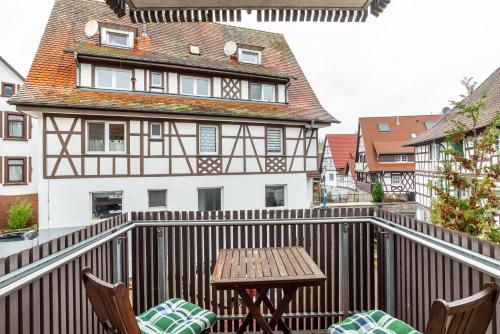 a balcony with a table and chairs and a building at SCHUSTERjunge Aparthotel in Sasbachwalden