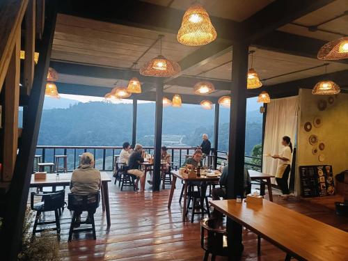 a group of people sitting at tables in a restaurant at Motho Homestay โมโทโฮมสเตย์ in Chom Thong
