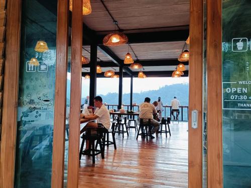 a group of people sitting at tables in a restaurant at Motho Homestay โมโทโฮมสเตย์ in Chom Thong