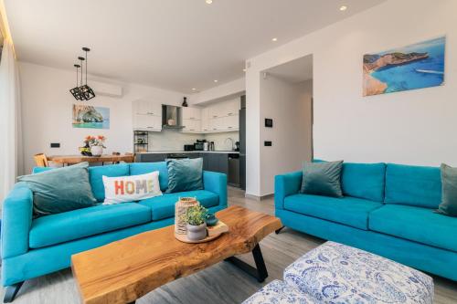 a living room with blue couches and a table at AKEA VILLAS in Tragaki