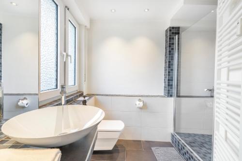 a bathroom with a white tub and a toilet at Urban Retreat Apartment - Whirpool - Top Lage in Cologne