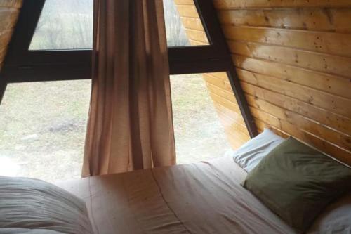 a bedroom with a bed in front of a window at 2brCabin-Fireplace-HotTub-Sauna-SkiResort in Bran