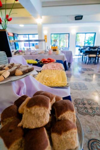 a table topped with different types of bread and cheese at Hotel Sierralago in Villa Carlos Paz