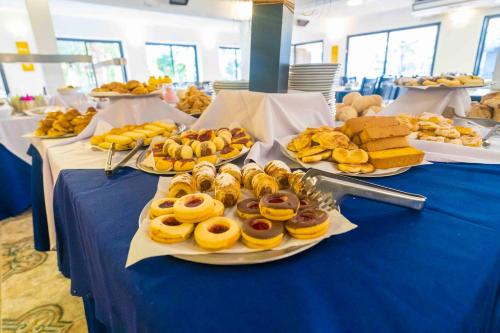 a blue table with plates of pastries and bread at Hotel Sierralago in Villa Carlos Paz