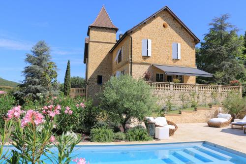 une villa avec piscine devant une maison dans l'établissement Manoir Majoral, à Vitrac