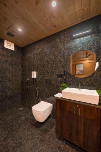 a bathroom with a toilet and a sink and a mirror at The Yoga Retreat l Place for Yoga I Meditation I Shanti & Dhayan l Vacations I Family Events I Kufri by Exotic Stays in Shimla