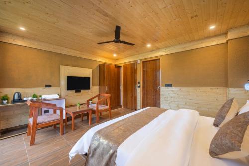 a bedroom with a bed and a desk and a television at The Yoga Retreat l Place for Yoga I Meditation I Shanti & Dhayan l Vacations I Family Events I Kufri by Exotic Stays in Shimla
