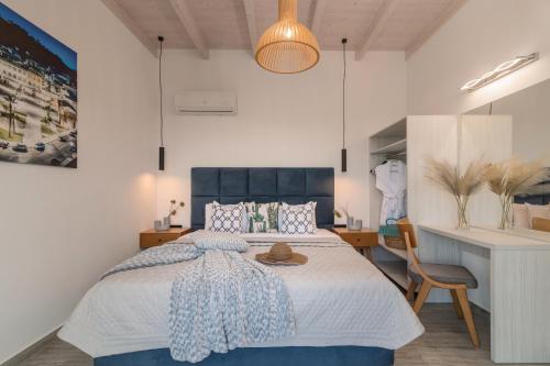 a bedroom with a bed with a blue headboard and a desk at AKEA VILLAS in Tragaki