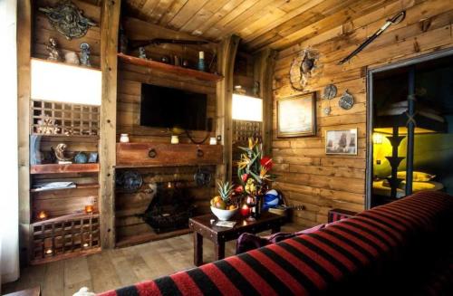 - un salon dans une cabane en rondins avec un canapé et une table dans l'établissement Camping 4 étoiles - Piscine - ccagieh, au Cap d'Agde