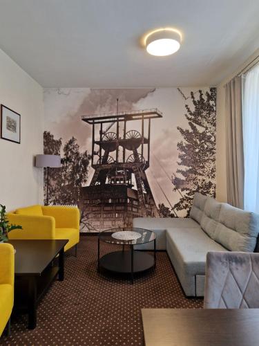 a living room with a couch and a wall mural at Boutique Hotel's Bytom in Bytom