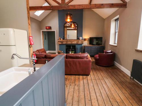 a living room with a couch and a kitchen at Cedar Cottage in Barnard Castle