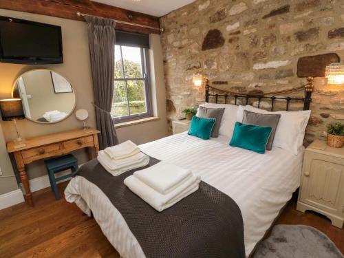 a bedroom with a large bed and a mirror at Cedar Cottage in Barnard Castle
