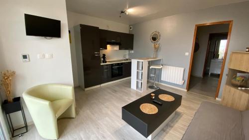 un salon avec un canapé et une table dans l'établissement Joli petit appartement sur les hauteurs de BRIVE, à Buissou