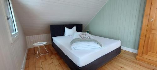 a small room with a bed with white sheets and pillows at Refugio Heiligkreuz in Hasle