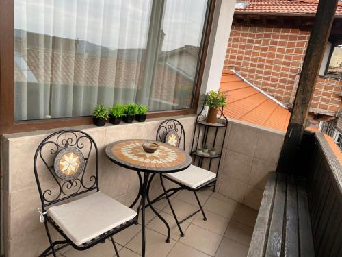 a small table and two chairs on a balcony at Guest House Divna in Veliko Tŭrnovo