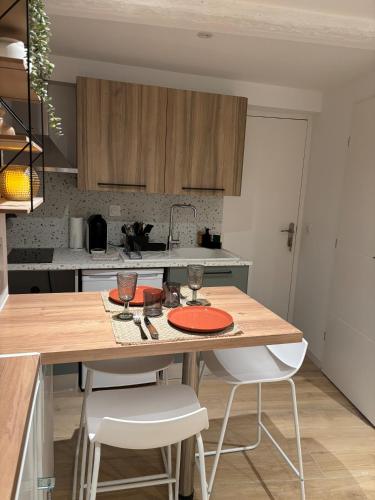 une cuisine avec une table en bois et 2 chaises dans l'établissement Appartement Ceyreste La Ciotat - jacuzzi, à Ceyreste