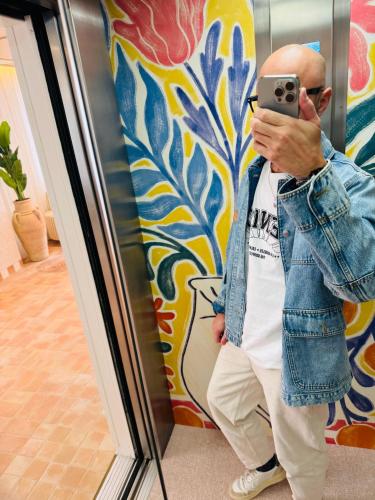 a man taking a picture in front of a wall at Hôtel Gabriel in Menton