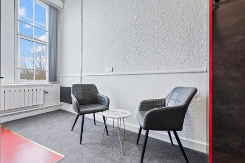 two chairs and a table in a room at Bright, airy space with Parking and Netflix Apt 112 in Dudley