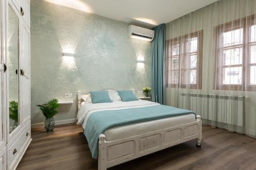 a bedroom with a large bed with blue sheets at Guest House Divna in Veliko Tŭrnovo