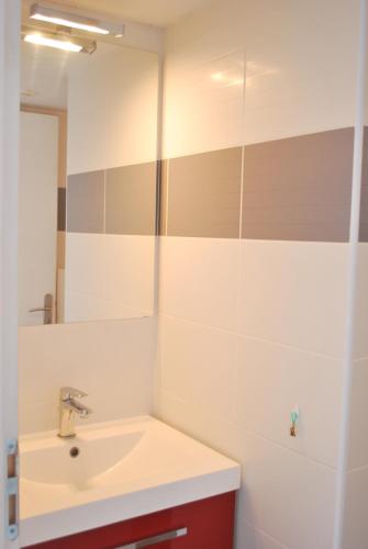 une salle de bain avec un lavabo et un miroir dans l'établissement Gîte de SAINT RIOM, à Paimpol