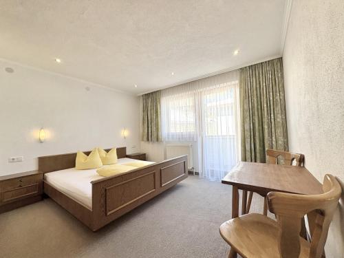 a bedroom with a bed and a desk and a table at Haus Sonnberg in Kappl