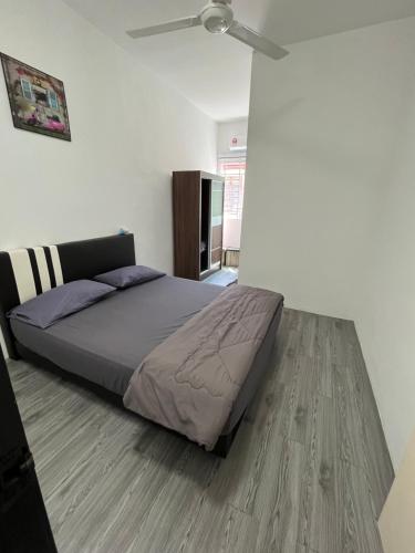 a bedroom with a bed and a ceiling fan at TCH Alor Setar Homestay in Alor Setar