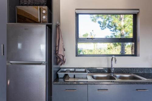 a kitchen with a stainless steel refrigerator and a sink at Forest Valley Cottages in Knysna