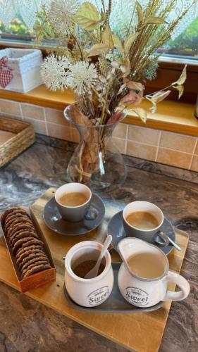 a tray with three cups of coffee and cookies at Drevenička Anička - Liptovská Mara in Liptovský Trnovec