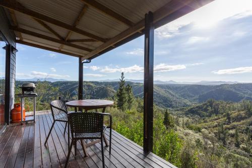 a table and chairs on a deck with a view at Forest Valley Cottages in Knysna