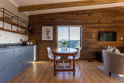 a kitchen and dining room with a table and a window at Forest Valley Cottages in Knysna