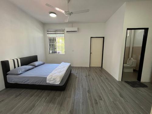 a bedroom with a bed and a ceiling fan at TCH Alor Setar Homestay in Alor Setar