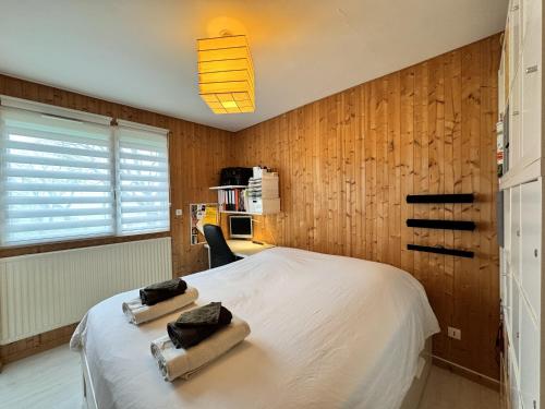 une chambre avec un lit avec deux serviettes dessus dans l'établissement L'Artois - Garage - Proche circuit - 4p, au Mans