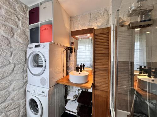 une salle de bain avec une machine à laver et un lavabo dans l'établissement L'Artois - Garage - Proche circuit - 4p, au Mans