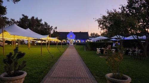 a brick walkway in front of a building with tents at Kievits Kroon Gauteng Wine Estate in Pretoria