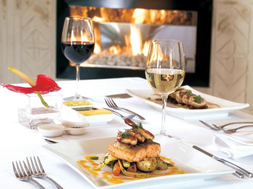 a table with a plate of food and two glasses of wine at Kievits Kroon Gauteng Wine Estate in Pretoria