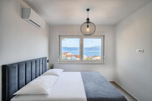 a bedroom with a bed and a window at Imola's Place - Sea-View & Pool in Slatine