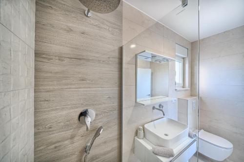 a bathroom with a sink and a toilet and a mirror at Imola's Place - Sea-View & Pool in Slatine