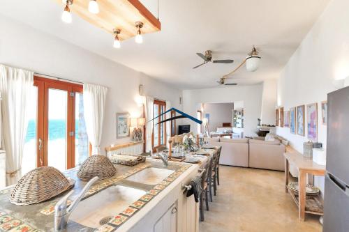 a large kitchen with a long table with chairs at The Charming Waterfront Retreat, with a swimming pool & direct access to the sea, ideal for large families, or a group of friends in Otzias