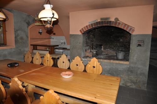 a dining room with a table and a brick oven at Chalupa Pod Návsí - Olešnice v Orlických horách in Olešnice v Orlických horách