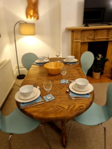 a wooden table with plates and wine glasses on it at The Bolt Hole in Brighton & Hove