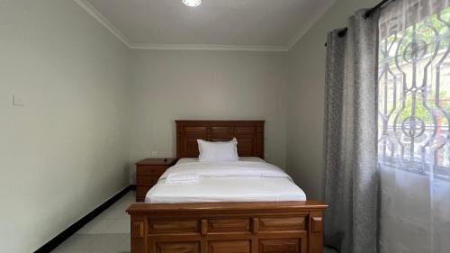 a small bedroom with a bed and a window at Kilimani Apartment in Arusha