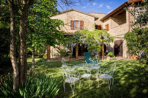 a table and chairs in the yard of a house at Agriturismo Casa Greppo in San Venanzo