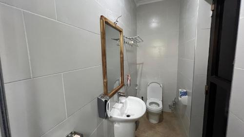 a bathroom with a toilet and a mirror on the wall at Kilimani Apartment in Arusha