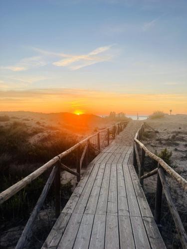 a wooden pathway to the beach at sunset at Villa Vista Mar La Marina Piscine privée in Elche