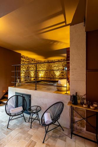 a room with two chairs and a fireplace at Domaine de Rymska & Spa - Relais & Châteaux in Saint-Jean-de-Trézy