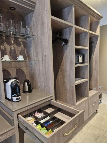 a kitchen with a wooden cabinet with wine bottles at Kievits Kroon Gauteng Wine Estate in Pretoria